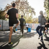 man in black t-shirt and black shorts running on road during daytime
